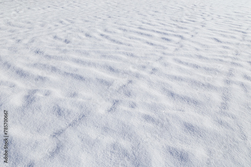 Landscape of fresh and clean snow on the ground in the winter on a sunny day, viewed from above. Abstract full frame textured background. Good as a natural winter season background with copy space.