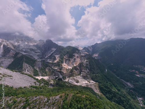 Aerial panorama of marble quarries Carrara Italy. Marble quarry top view. Aerial panorama on the Carrara marble quarry. Famous marble quarry in the mountains of Italy. Cumulus clouds over mountains.