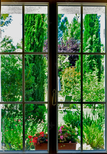 widok ogrodu i k  cika wypoczynkowego za oknem domu  okno z widokiem na ogr  d  window overlooking the garden