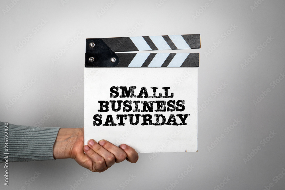 Small Business Saturday. Hand holding movie clapper