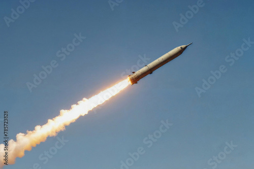 A large military ballistic rocket is flying through the blue sky. War concept