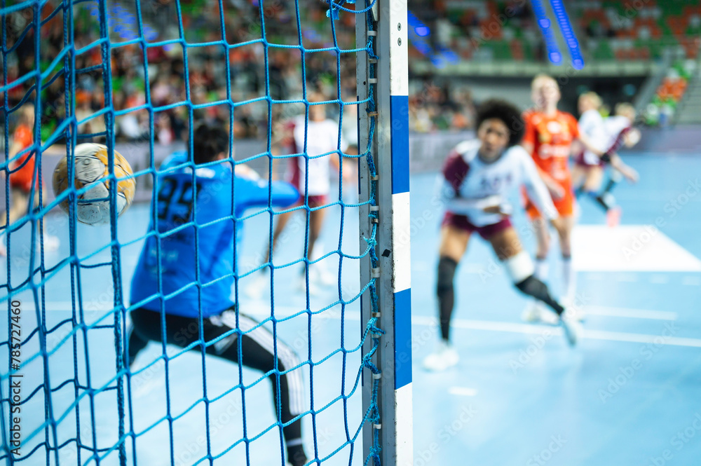 Detail of handball goal post with net and game in the background. - obrazy, fototapety, plakaty 