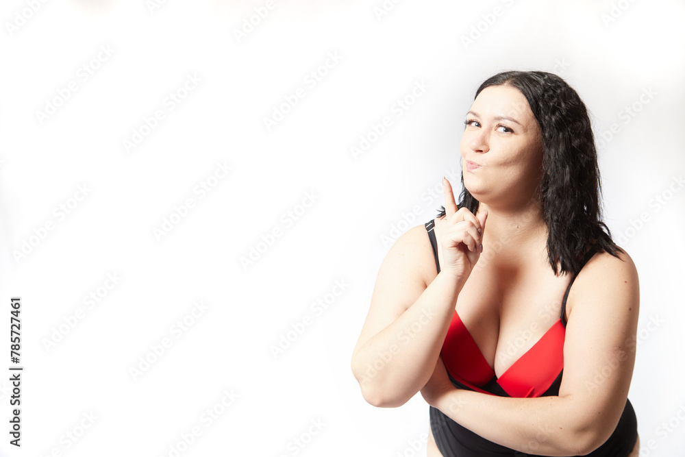Portrait of attractive dreamy thick woman in red black swimsuit posing on white background. Body positive, photo shoot, selfie. Funny plus size model Portrait of attractive dreamy thick woman in red black swimsuit posing on white background. Body positive, photo shoot, selfie. Funny plus size model