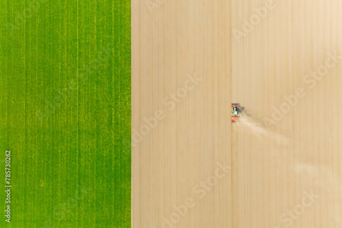 Agricultural transport. Tractor in the field. Working the land. Aerial view of the field. Landscape from a drone. Light and shadow. Natural background from drone. View from above. Agriculture. © biletskiyevgeniy.com