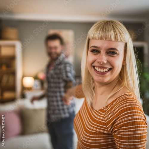 One adult couple dance together and have fun at living room at home