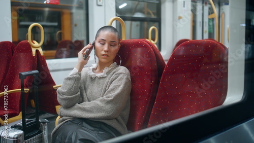 Tired tourist calling mobile phone in train. Short hair woman talking smartphone