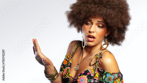 Disgust ethnic retro girl with big hair and 1970s style clothing gesturing with her hand © bartsadowski