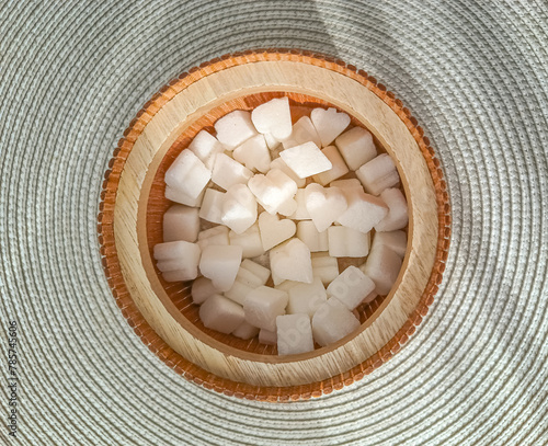 Heart shaped sugar cubes in a wooden container, top view 