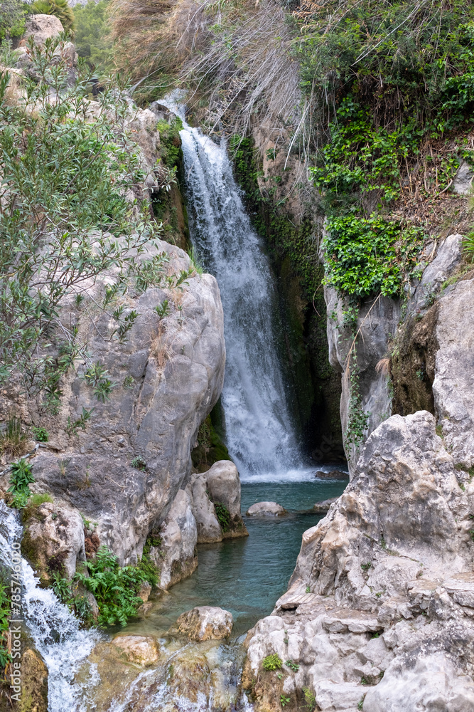 Secluded waterfall cascades into a serene rock pool, a hidden gem tucked away in a lush Spain mountain ravine. Secluded waterfall cascades into a serene rock pool, a hidden gem tucked away in a lush Spain mountain ravine.