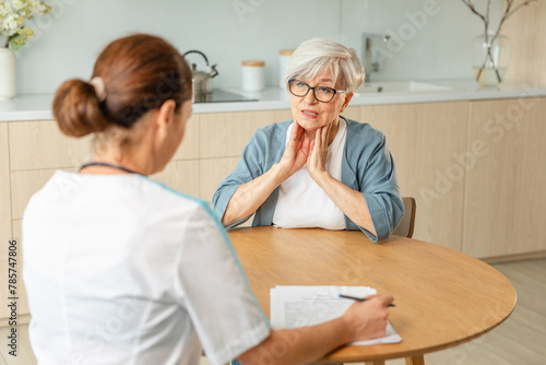 Female doctor examining older senior woman in doctor office or at home. Old woman lady patient and doctor have consultation in hospital room. Medicine healthcare medical checkup. Visit to doctor