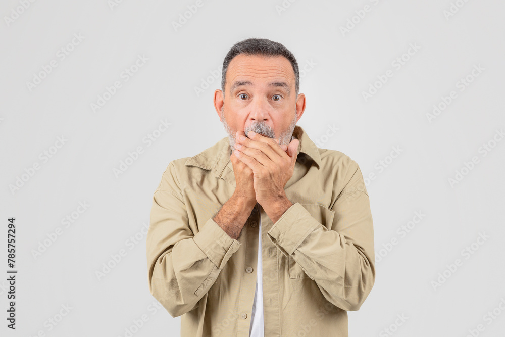 Elderly man covering mouth in surprise on white Elderly man covering mouth in surprise on white