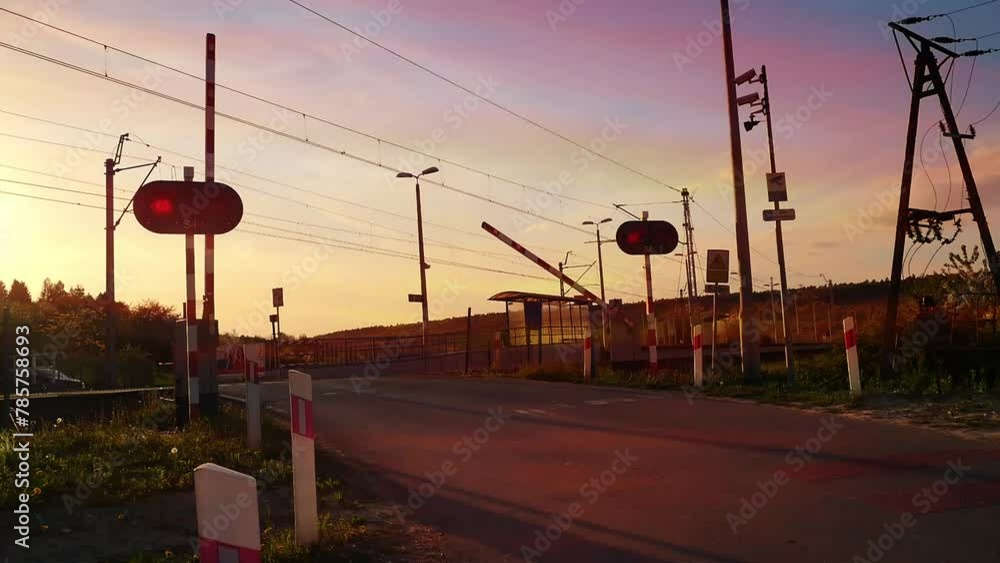 Guarded railroad crossing gate closing before local train passing Guarded railroad crossing gate closing before local train passing
