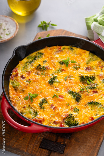 Healthy frittata or quiche with broccoli and red pepper whole in a cast iron pan