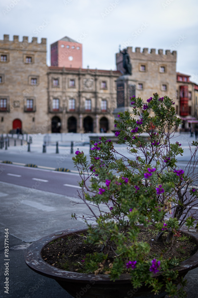 Gijón's iconic plaza, adorned with vibrant purple blooms, stands as a cultural gem.