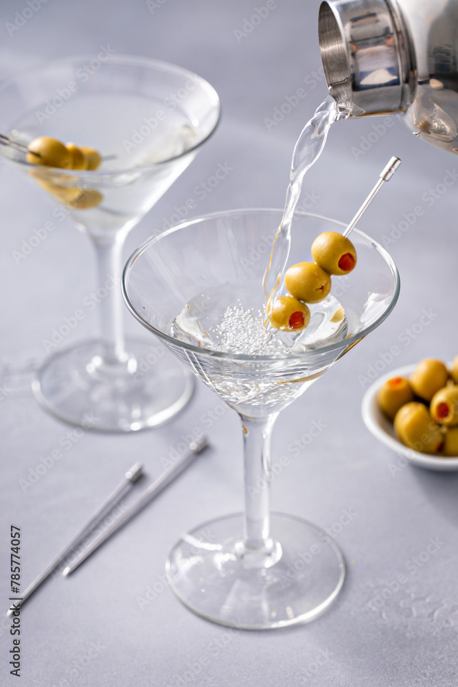 Traditional martini cocktail being poured in a glass