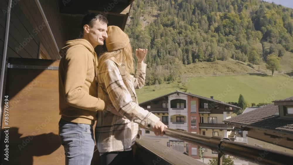 Happy couple at autumn mountains talking, hugging and drinking tea on terrace with beautiful view Happy couple at autumn mountains talking, hugging and drinking tea on terrace with beautiful view
