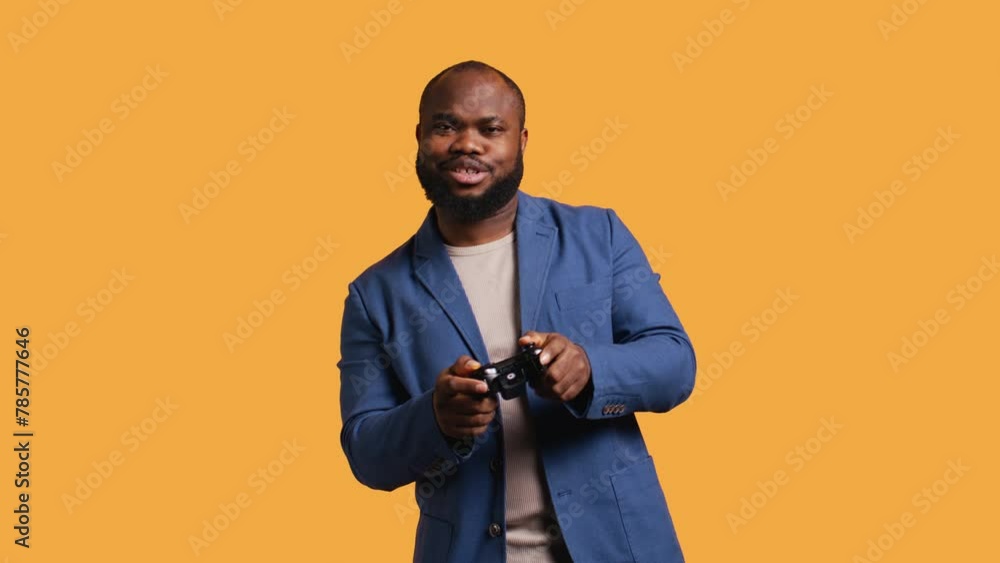 Cheerful african american gamer showing thumbs up sign gesturing holding controller, playing videogames. Joyful person excited to do gaming, doing approving hand gesture, studio background, camera B Cheerful african american gamer showing thumbs up sign gesturing holding controller, playing videogames. Joyful person excited to do gaming, doing approving hand gesture, studio background, camera B