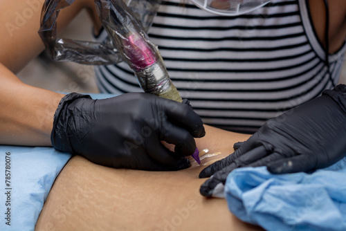 Woman tattooing stretch marks on a woman's skin