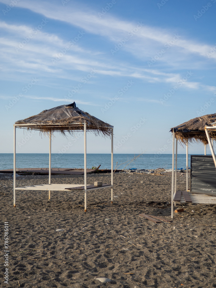 Abandoned decorative houses with thatched roofs on the seashore. Off-season. Lack of tourists. Abandoned decorative houses with thatched roofs on the seashore. Off-season. Lack of tourists.