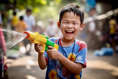 Laughing Thai boy using water pistol at Songkran festival  photo
