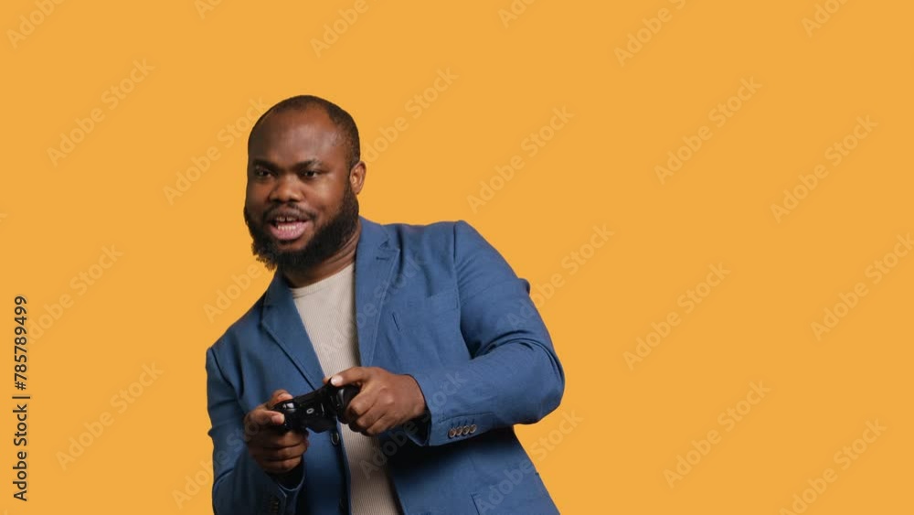 Cheerful african american gamer showing thumbs up sign gesturing holding controller, playing videogames. Joyful person excited to do gaming, doing approving hand gesture, studio background, camera A Cheerful african american gamer showing thumbs up sign gesturing holding controller, playing videogames. Joyful person excited to do gaming, doing approving hand gesture, studio background, camera A