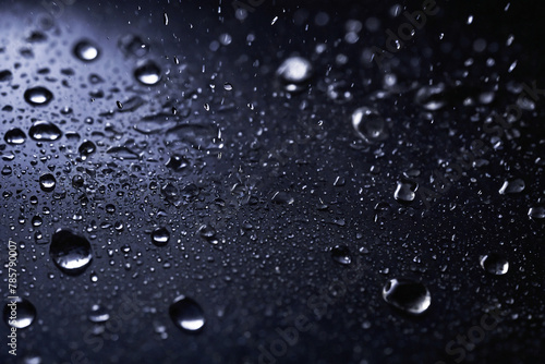 A close up of water droplets on a dark surface