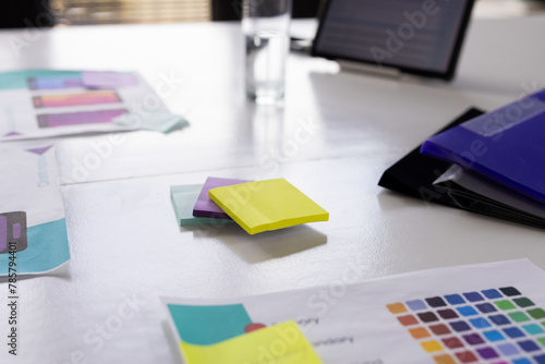 Colorful sticky notes and app design papers are lying on a table in a modern business office photo
