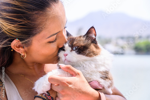 Close-up of a tender moment between a lady and her beloved pet cat outdoor