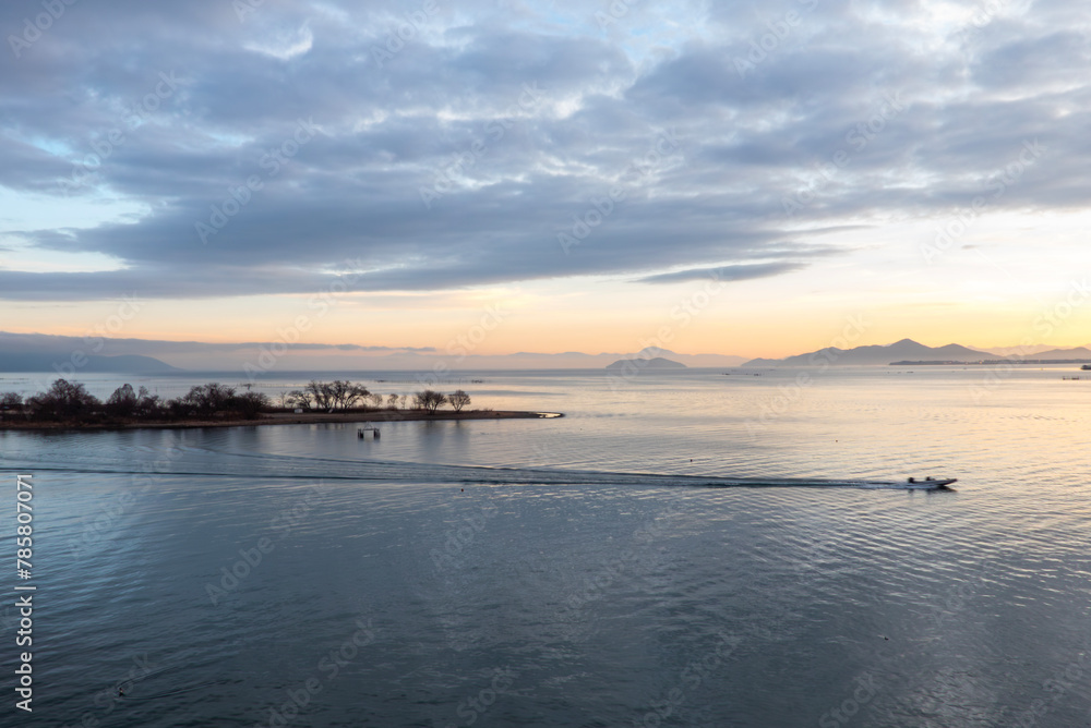 琵琶湖の早朝　朝焼けの中バスボートが出航し美しい航跡　琵琶湖大橋橋上から撮影