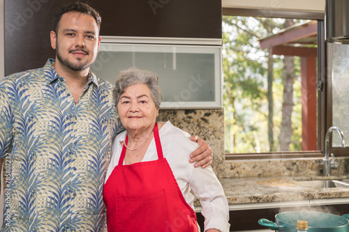 Portrait of a son with his mother in the kitchen of his mother's house. photo