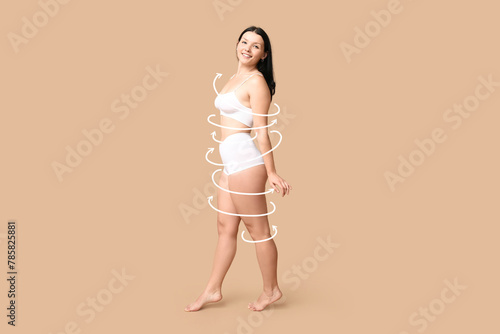 Body positive woman in underwear smiling on beige background © Pixel-Shot