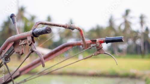 Steering of rice field tractor machine on watery agricultural land in the countryside in Indonesia.