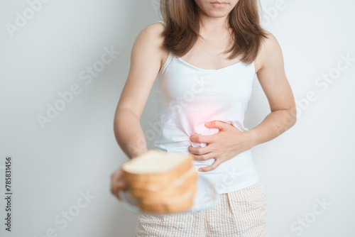 Gluten intolerance, Gluten free and celiac disease or wheat allergy concept. woman hold Bread and having abdominal pain after eat gluten. stomach ache, Nausea, Bloating, Gas, Diarrhea and Skin rash photo