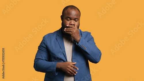 African american man covering mouth in disbelief, feeling upset by events, isolated over studio background. BIPOC person shaking head, left speechless by troubling news, camera A