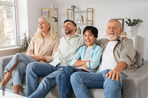 Little boy with his family sitting on sofa at home