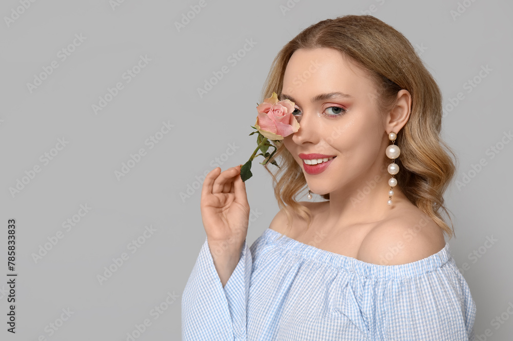 Happy young woman with beautiful rose on grey background Happy young woman with beautiful rose on grey background