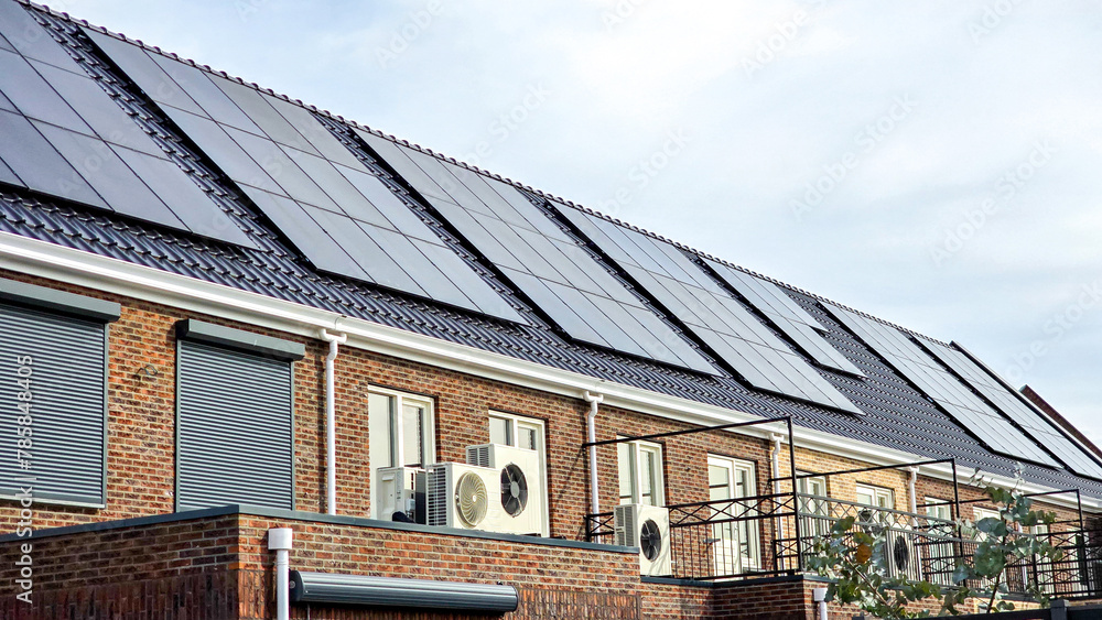 Newly build houses with solar panels attached on the roof against a sunny sky