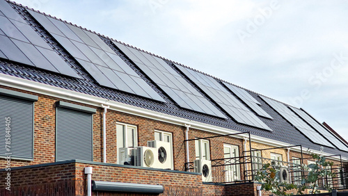Newly build houses with solar panels attached on the roof against a sunny sky