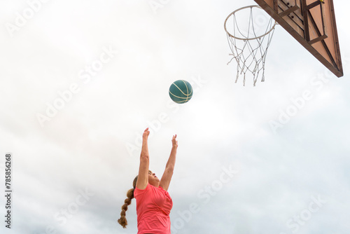 Disabled senior woman playing basketball in the playground on a cloudy day. healthy old age concept