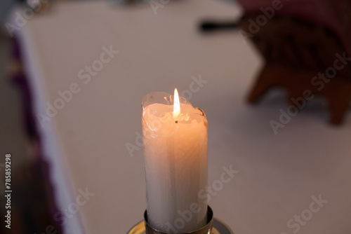Photograph of a candle inside a church.
