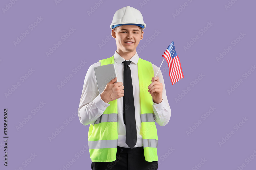 Male architect with USA flag and tablet computer on lilac background Male architect with USA flag and tablet computer on lilac background