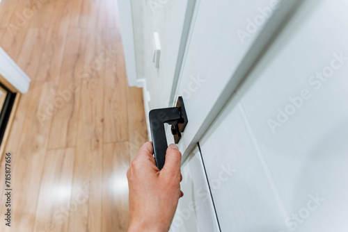 Hand on door handle, opening hardwood door in wooden building