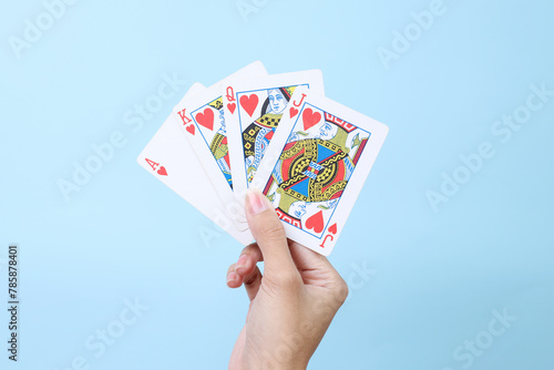 Playing cards in hand isolated on blue background