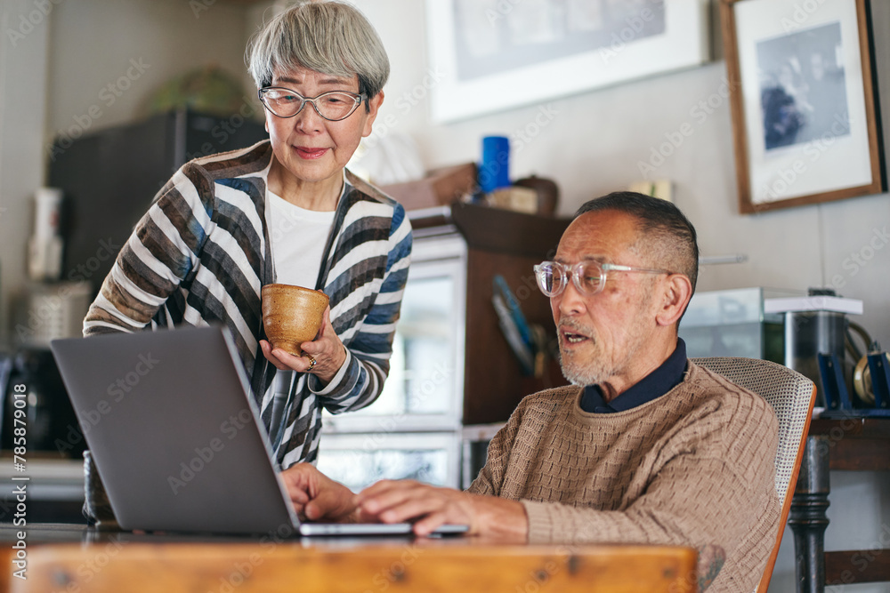 パソコンでインターネットを楽しむ日本人シニア夫婦 パソコンでインターネットを楽しむ日本人シニア夫婦