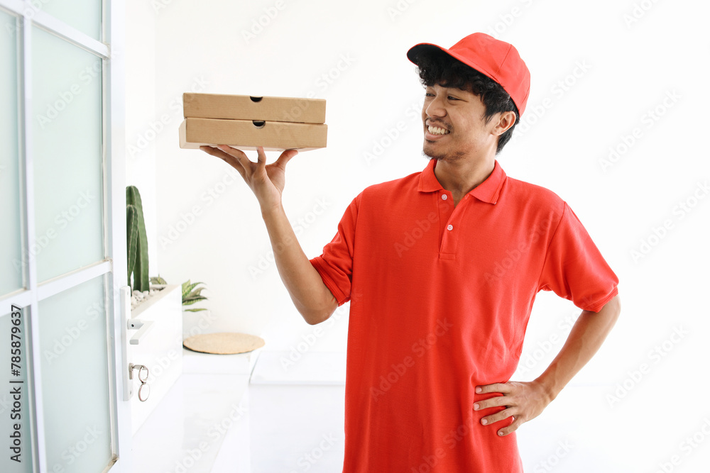 Pizza Delivery Man Smiling and Lifting Boxes of Pizza in Front of The House Pizza Delivery Man Smiling and Lifting Boxes of Pizza in Front of The House