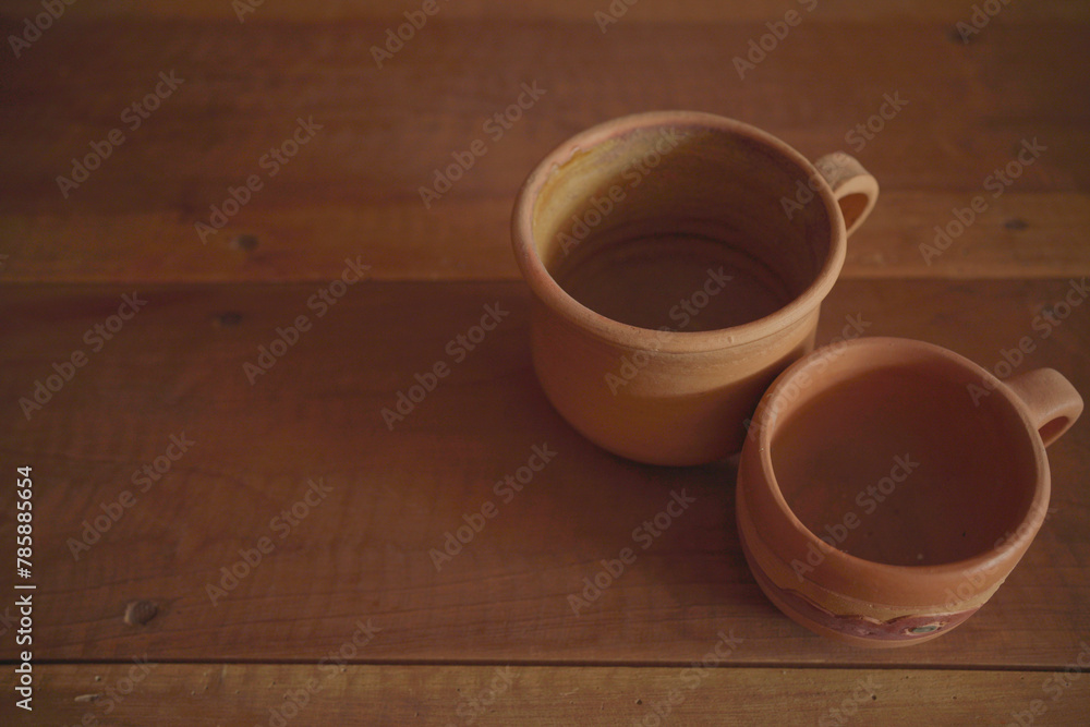Empty earthenware mug on wooden table background. Empty earthenware mug on wooden table background.