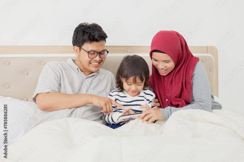 family looking at a mobile phone on bed