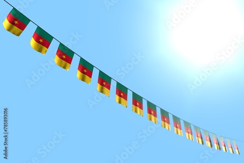 cute many Cameroon flags or banners hanging diagonal on string on blue sky background with bokeh - any holiday flag 3d illustration..