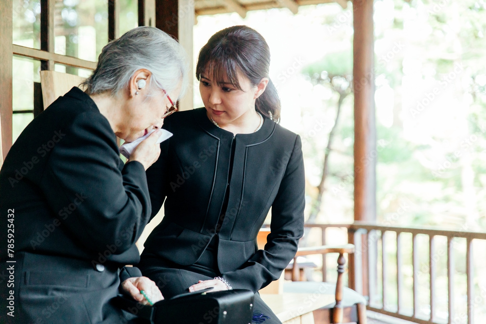 お葬式で泣く喪服を着た遺族の高齢者女性と若い日本人女性
お葬式で泣く喪服を着た遺族の高齢者女性と若い日本人女性