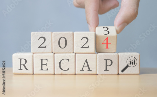 Fototapeta Naklejka Na Ścianę i Meble -  business finance concept, economic summary 2023, business plan 2024, words RECAP 2023 and 2024 on a wooden cube